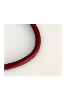 Detail of red leather bag handle showing pebble grain texture and neat stitching on white background