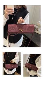 Nahaufnahme der weinroten Schlangenleder-Handtasche mit goldener Knotenschnalle und Gurt