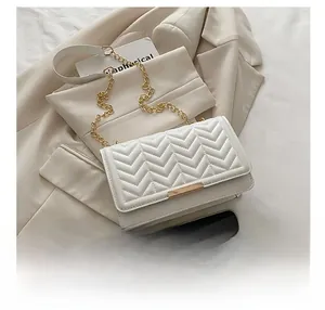 Comparaison de taille détaillée du sac à chaîne blanc matelassé en V avec un téléphone