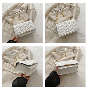 Détails d'un sac à rabat blanc matelassé avec chaîne dorée et motif chevron
