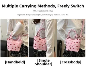 Pink bucket bag with cherry print shown in handbag, shoulder, and crossbody styles