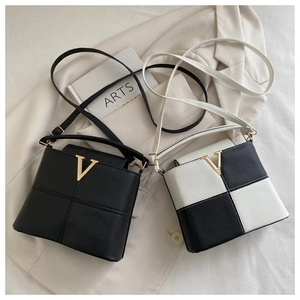 Close-up of litchi pattern leather handbags with golden V-shaped metal buckles