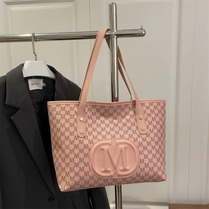 Detailed macro view of pink PU tote bag featuring all-over M pattern and logo ornament
