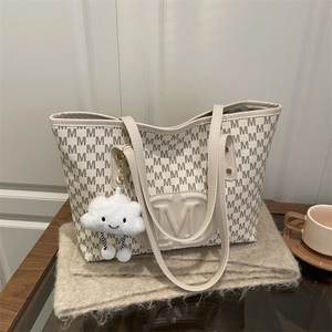 Detail of cream PU tote bag with M-pattern print and cute cloud plush charm