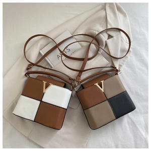 Detail of square crossbody bags with lychee pattern leather and metal V-shaped buckle