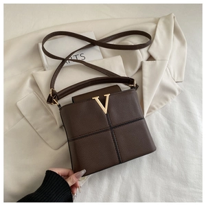 Detail of lychee pattern leather bag with gold V-logo and black cross stitching
