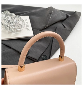 Nahaufnahme der rosa Ledertasche mit goldener Hardware und stilvollem Nahtdetail am Griff