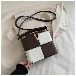 Detailed close-up of brown and beige checkerboard leather texture with gold V logo