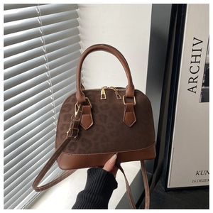 Detailed close-up of brown leopard print shell bag with gold hardware and leather strap