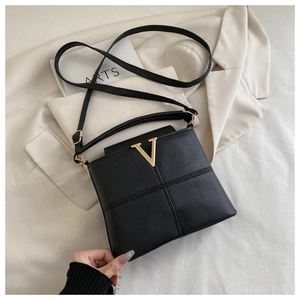 Detail of black pebbled leather handbag with gold V logo and cross-stitch pattern