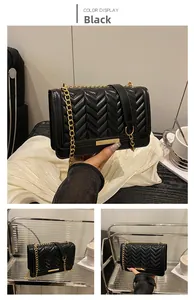 Détail du sac en similicuir noir surpiqué en V avec chaîne dorée et boucle métal