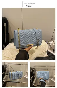 Détail d'un sac bandoulière bleu clair avec matelassage en V et chaîne en métal doré