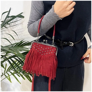 Detail of red vintage tassel handbag with silver rivets and metal frame closure