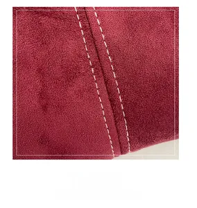 Macro detail of wine red suede bag featuring precise white stitching and fine velvet texture