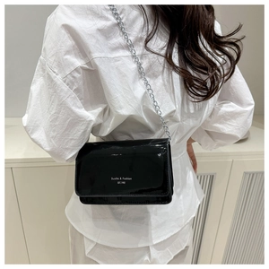 Détail du sac en cuir verni noir brillant avec chaîne argentée et logo Sunita & Fashion