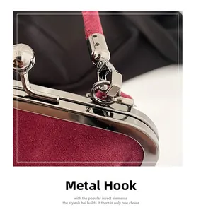 Detail of vintage silver metal hook and clasp on a deep red velvet crossbody bag