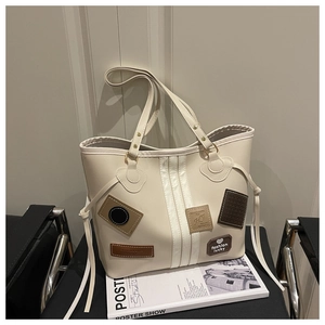 Detail of cream white leather tote bag with vintage patches and vertical stripe texture