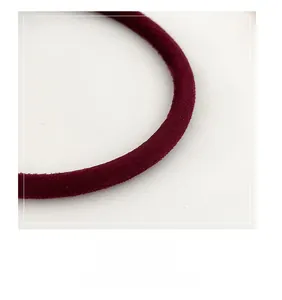 Close-up of a burgundy suede-textured handle with round structure and soft finish