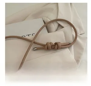Detailed macro view of khaki shoulder strap with artisanal knots and silver metal tips