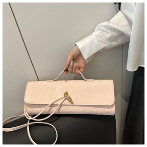 Detail der hellrosa Clutch mit Schlangenprägung, goldenem Knotenschluss und Riemen