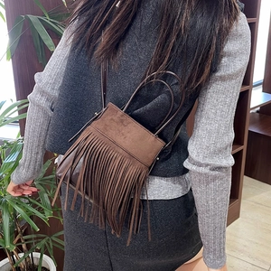 Retro bohemian fringe bucket bag in dark brown suede styled on model for daily outfit