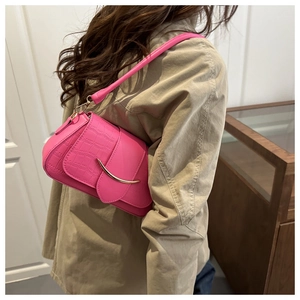 Dettaglio borsa in pelle coccodrillo rosa con fibbia dorata a mezzaluna elegante