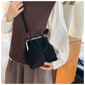 Close-up of a vintage black doctor bag with white stitching and metal clasp detail