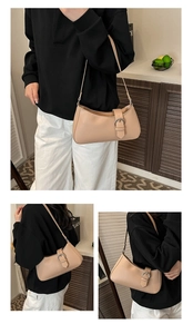 Chic beige crescent underarm bag with silver buckle and leather texture on a female model