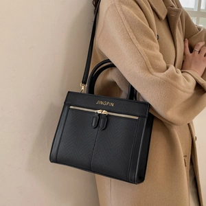 Classic black faux leather tote bag with gold zippers and adjustable shoulder strap