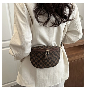 Macro detail of deep brown vintage monogram waist bag with smooth metal dual zippers