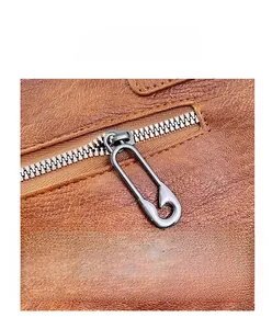 Detailed macro of vintage brown leather bag with unique silver safety pin zipper hardware