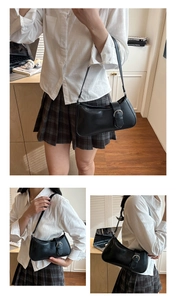 Detail showing the silver metal buckle and smooth black leather on the retro baguette bag