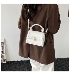 White minimalist square handbag with twist handle and gold twist lock detail
