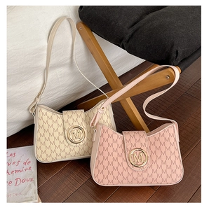 Primo piano di borse sottobraccio a mezzaluna in beige e rosa con fibbie dorate in metallo