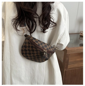 Detail of vintage brown patterned chest bag with wide jacquard strap and gold zippers