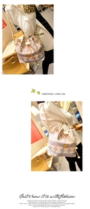 Detail of ethnic print bucket bag with golden chain strap and pearl drawstring charms