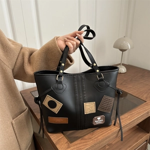 Retro black leather tote bag with vintage patches and gold hardware for women