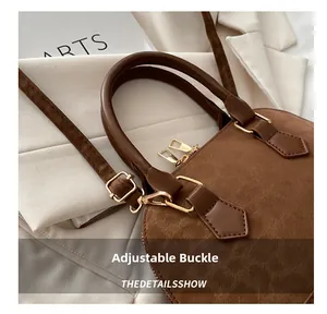 Detail of dark brown shell bag showing adjustable shoulder strap and golden metal buckle