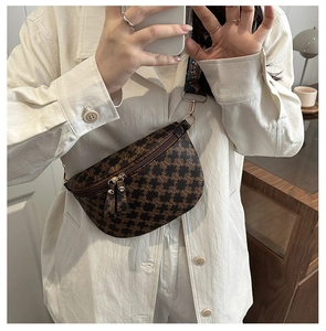 Detailed view of brown monogram fanny pack worn as a crossbody bag with wide strap