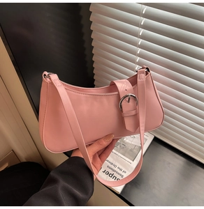 Detailed view of pink hobo bag featuring silver buckle accents and textured faux leather
