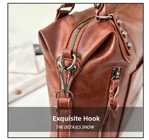 Detail shot of the vintage brown leather bag featuring metallic hooks and silver studs