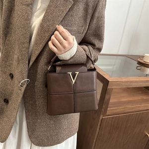 Brown textured leather handbag with gold V buckle and elegant top handle for women