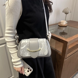 Borsa a tracolla grigia minimalista con patchwork a motivi e fibbia dorata indossata da modella