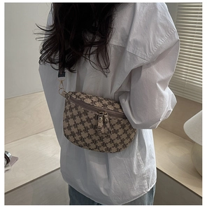 Close-up of retro monogram pattern belt bag with gold zippers and stylish woven strap
