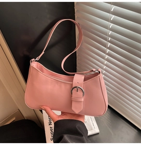 Detail of light pink baguette bag with large silver buckle closure and slim shoulder strap