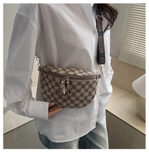 Detail of vintage monogram fanny pack with retro pattern and blue embroidered strap