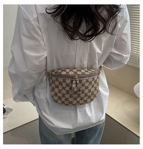 Detail of vintage plaid waist bag featuring retro M-pattern print and gold metal buckles