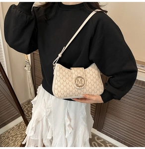Dettaglio borsa a spalla beige in PU con motivo monogramma e logo M in metallo