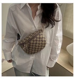 Close-up of khaki canvas belt bag featuring vintage letter M patterns and adjustable wide strap