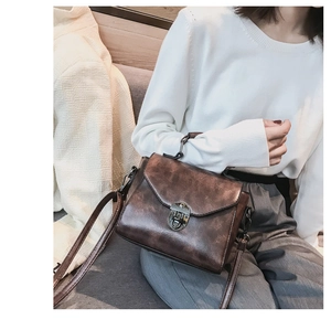 Dettaglio borsa a tracolla vintage in pelle marrone marmorizzata con chiusura metallica